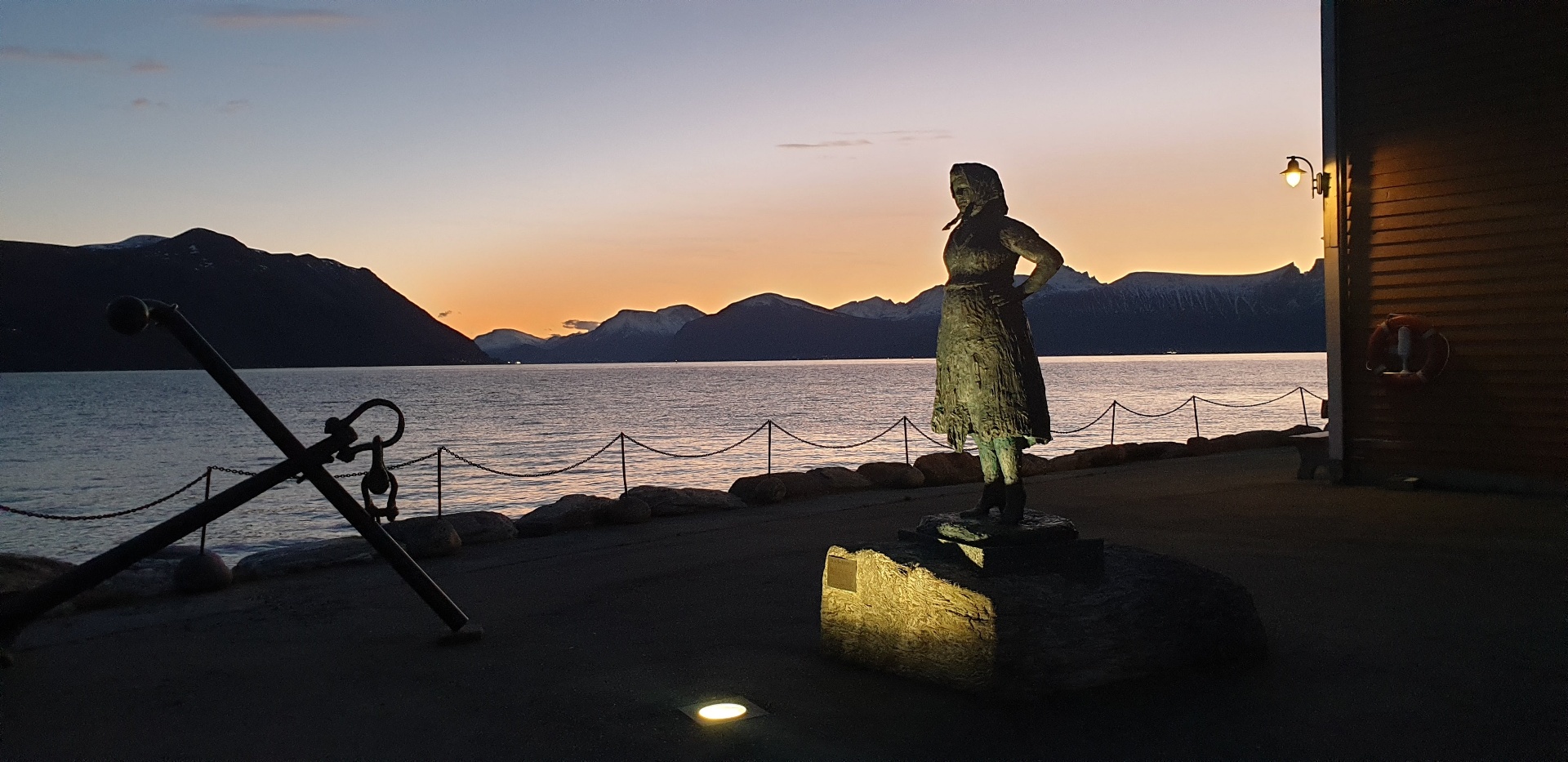 Statue av fiskarkona ved sjøen i solnedgang