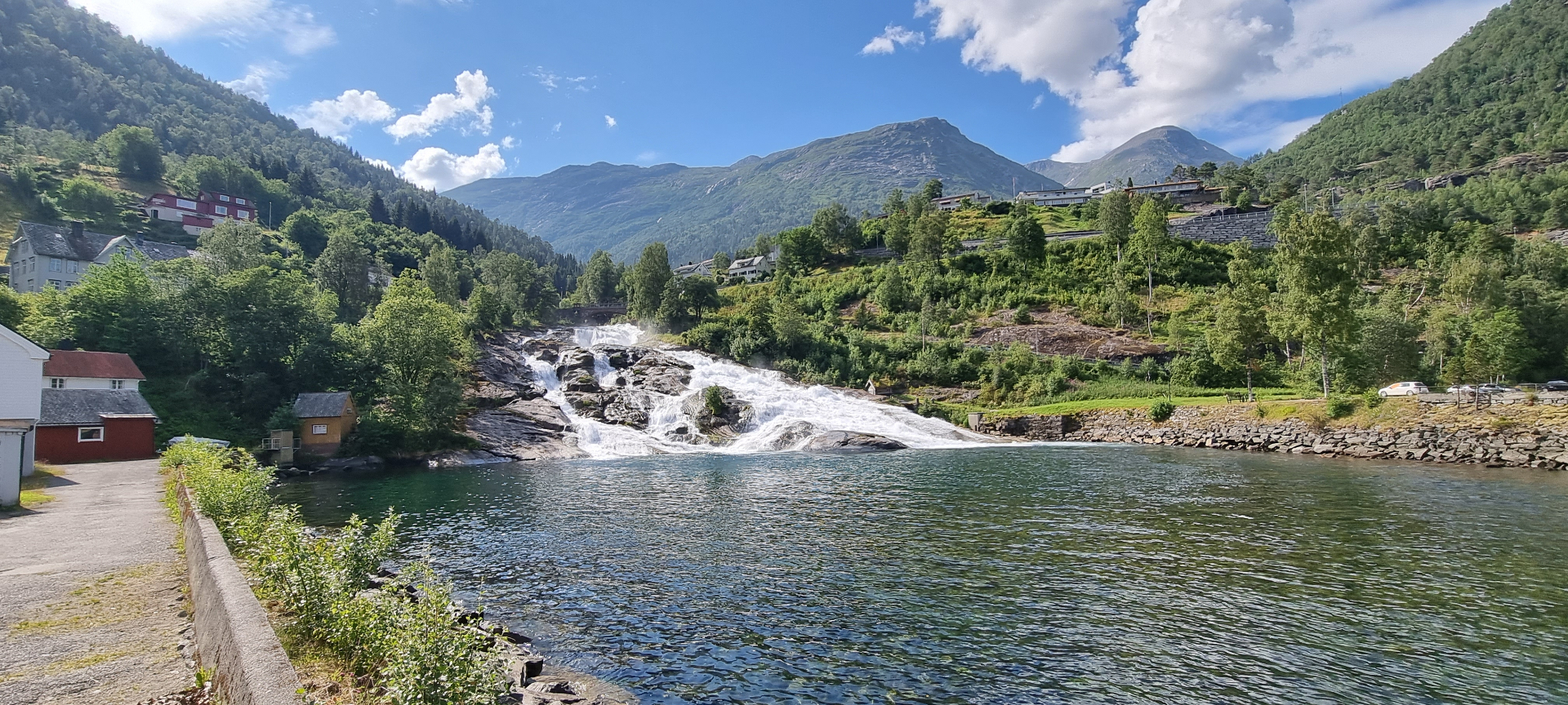 Hellesylt waterfall running through the village with mountains and houses around