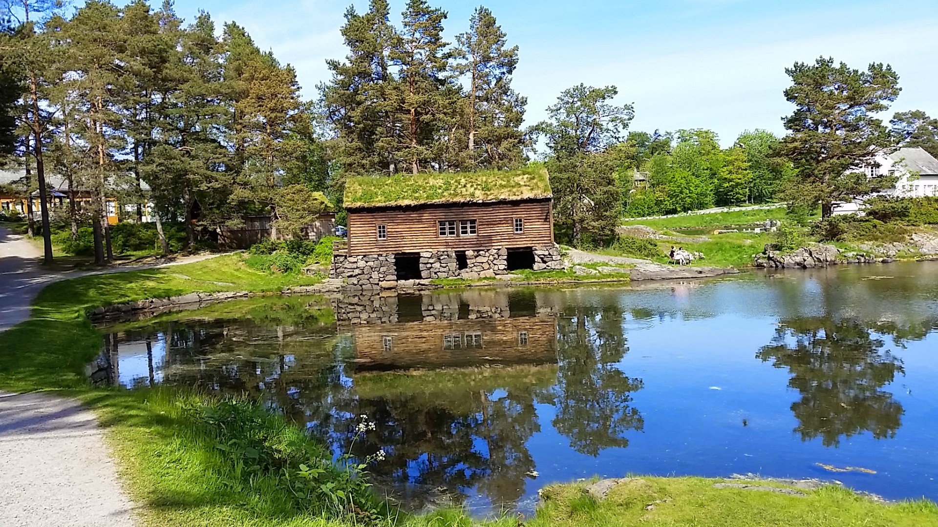 Boathouse with sod roof reflected in the water at Borgundgavlen