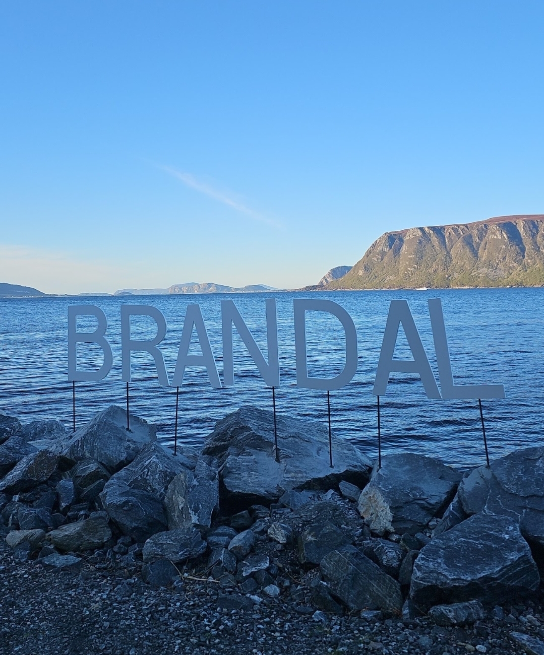 BRANDAL-skilt ved sjøen med utsikt mot Hareidlandet