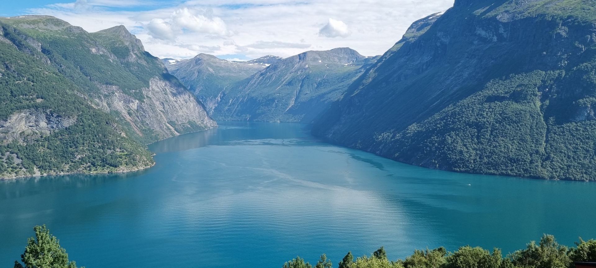 View from Ljøen viewpoint over the Hjørundfjorden with turquoise water and high mountains